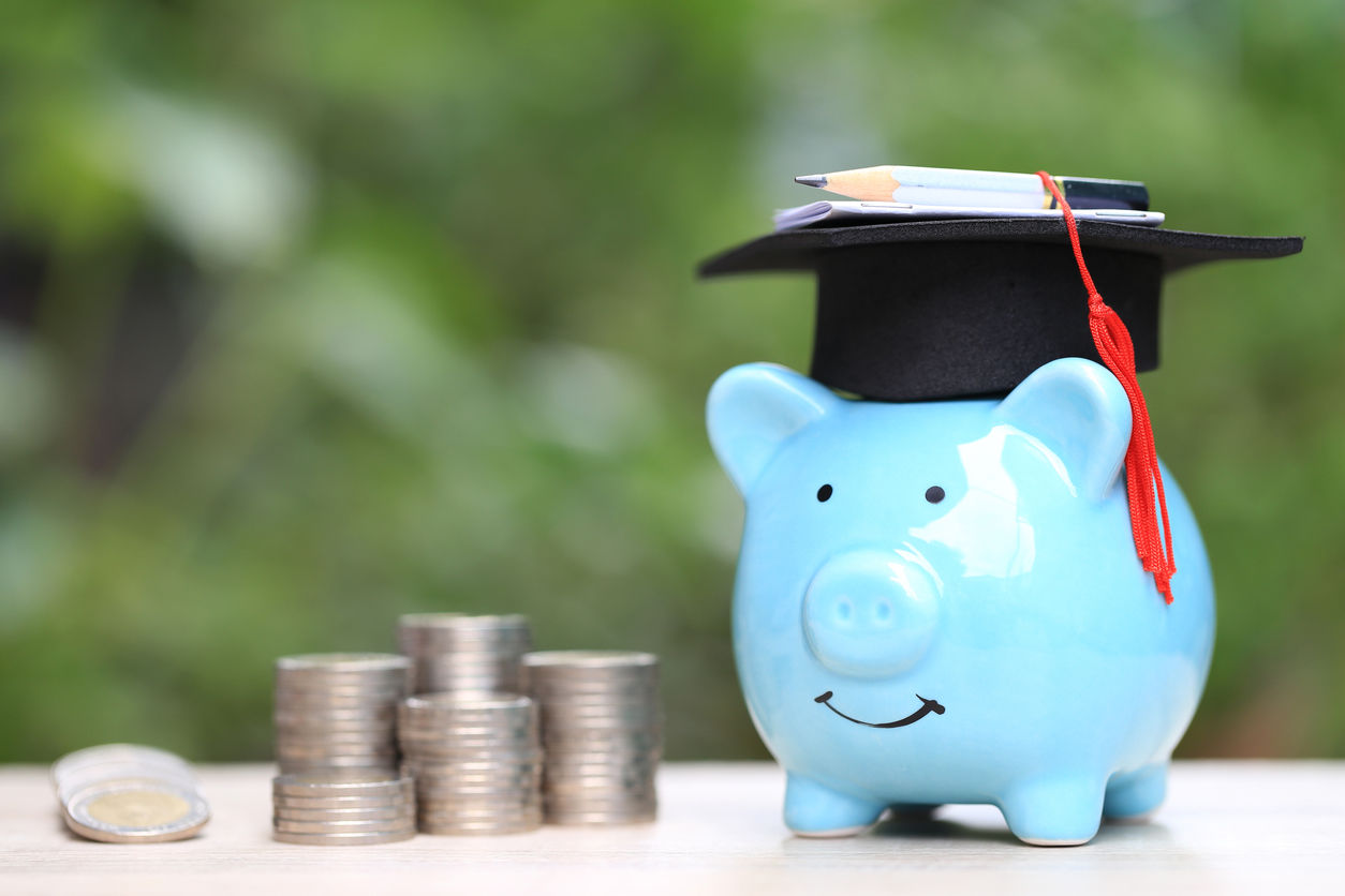 Saving money for education concept, Growing stack of coins money with graduation hat on piggy on nature green background
